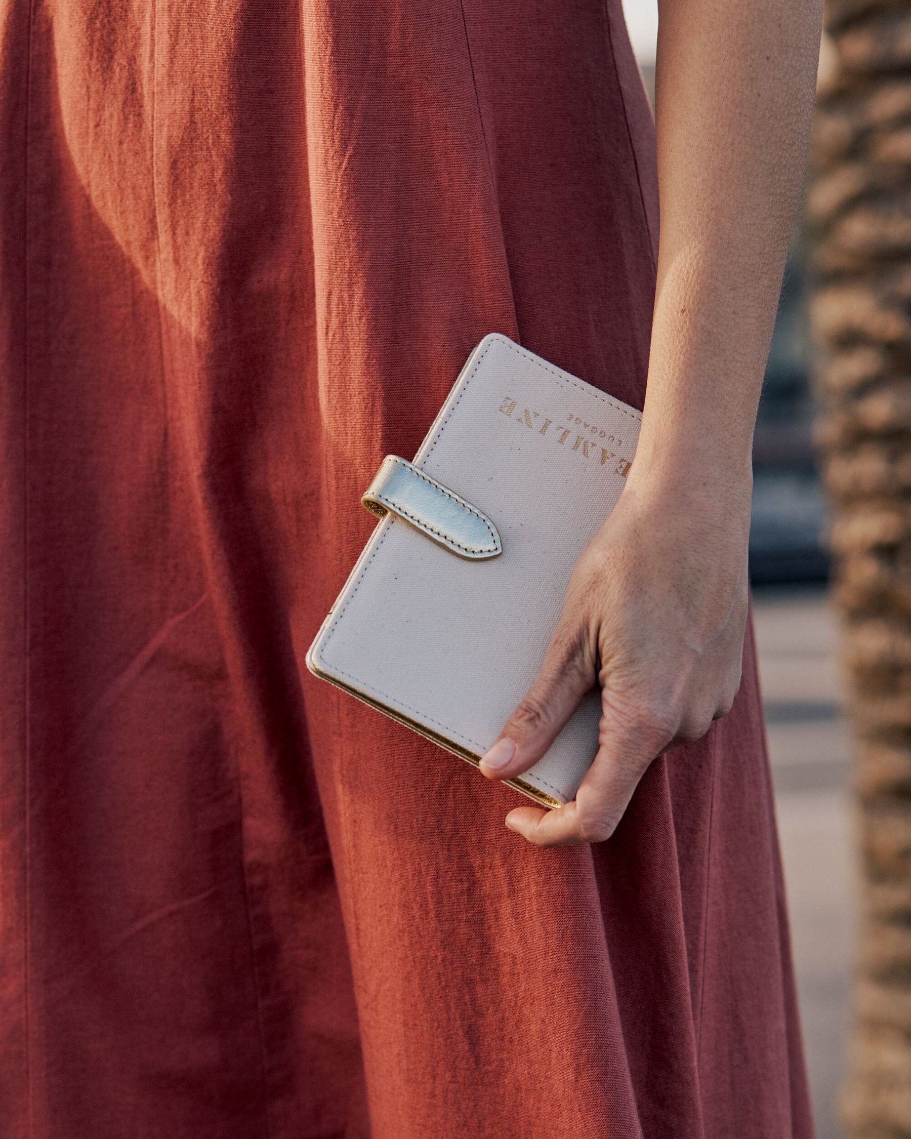 Lifestyle close up image of model with the Navigator passport holder in white with gold trim