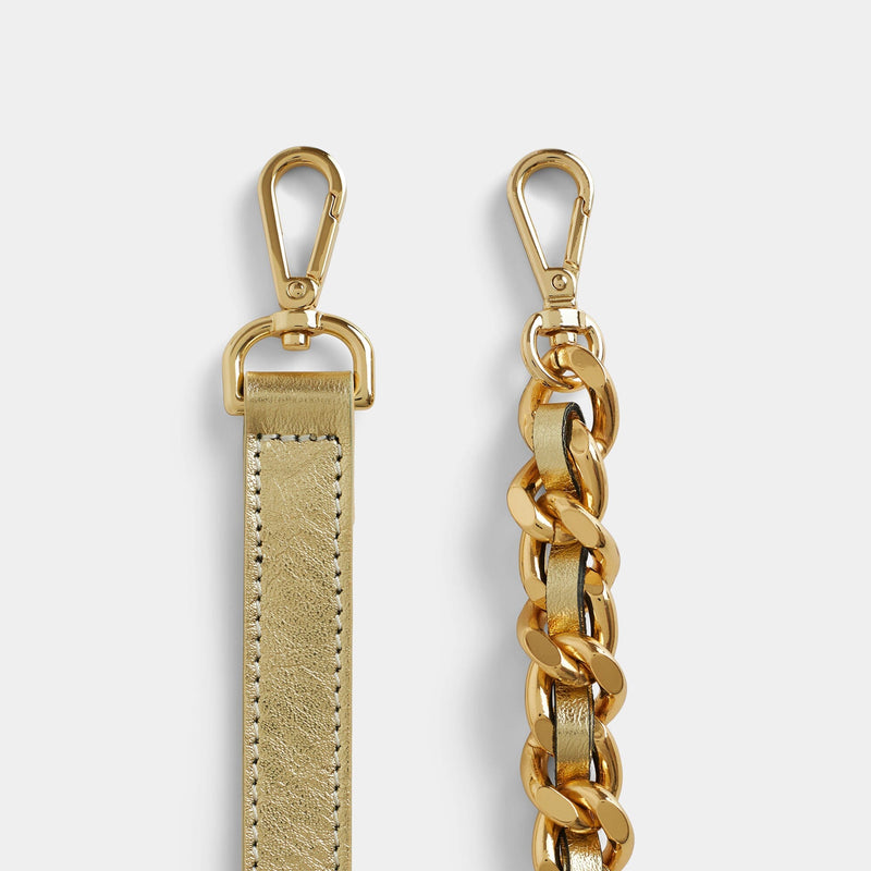 Close up view of the detachable gold leather strap and the chain strap