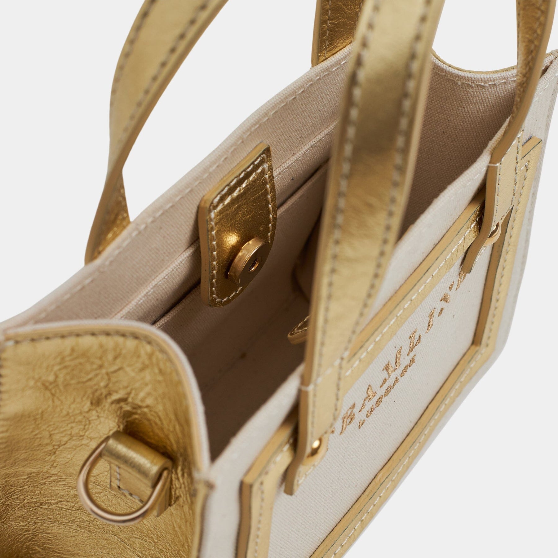 Open product view of the Navigator leather mini tote in ecru canvas with gold accents and trims