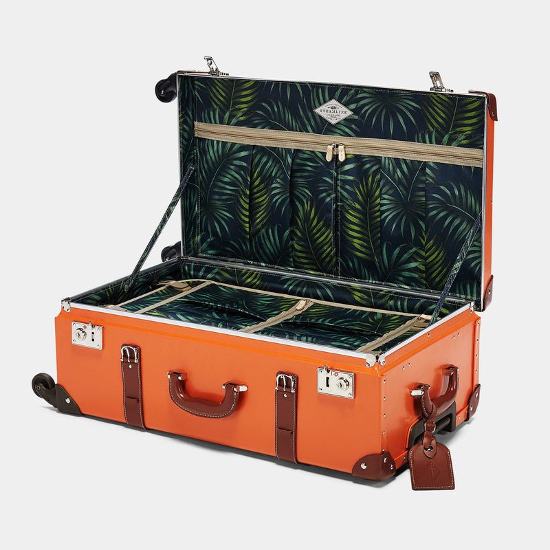 Open product view of the check-in Anthropologist leather suitcase in orange with green palms printed lining and brown leather luggage tag