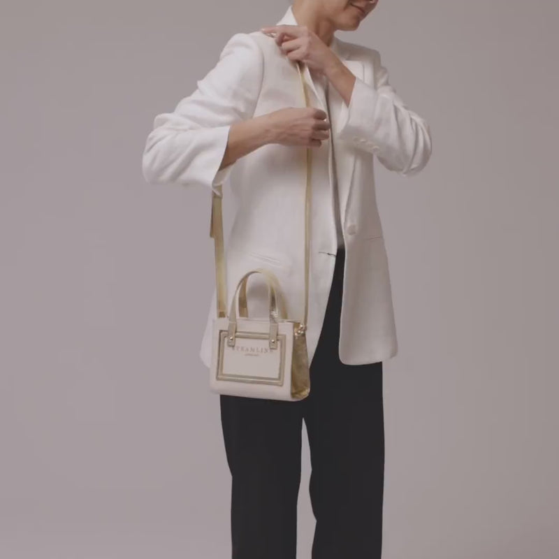 Video of model with the Navigator leather mini tote in ecru with gold accents, trims and leather strap