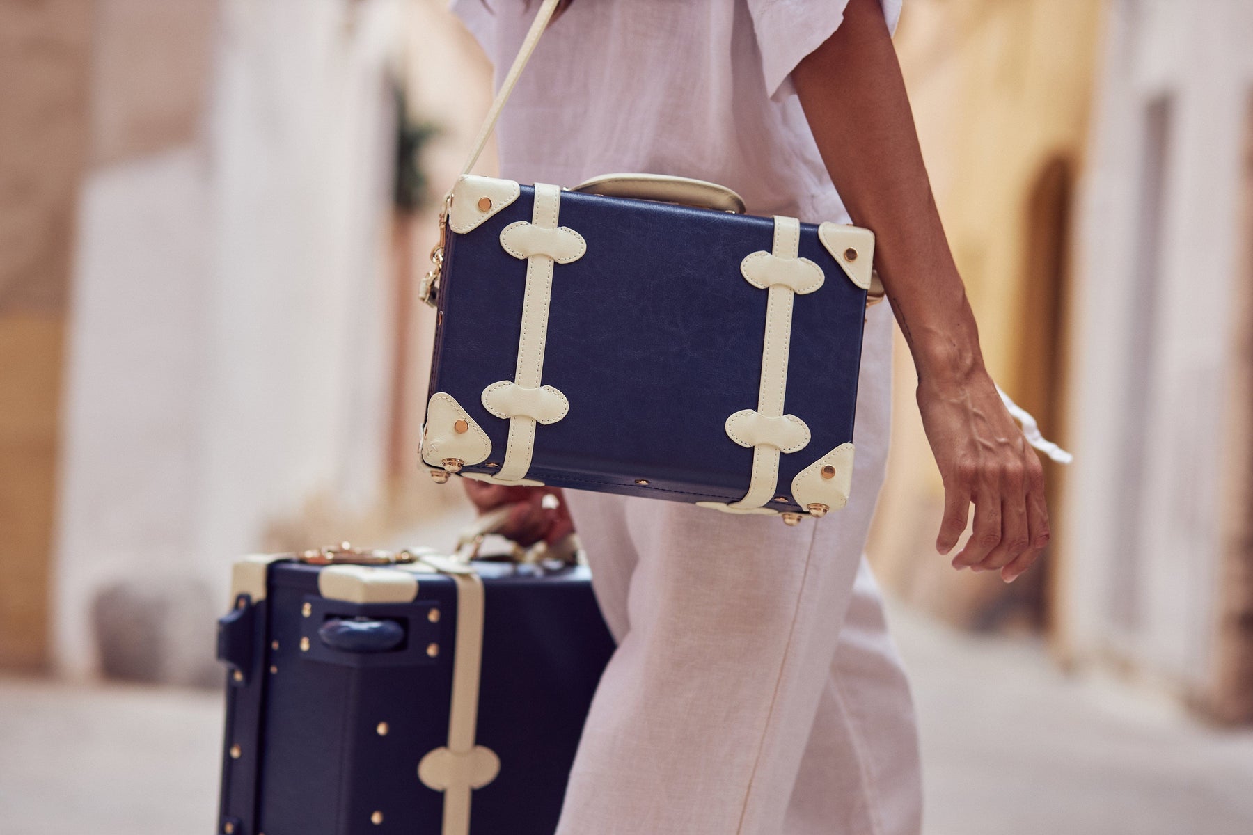 Lifestyle image of model with the Entrepreneur vegan leather suitcases in navy