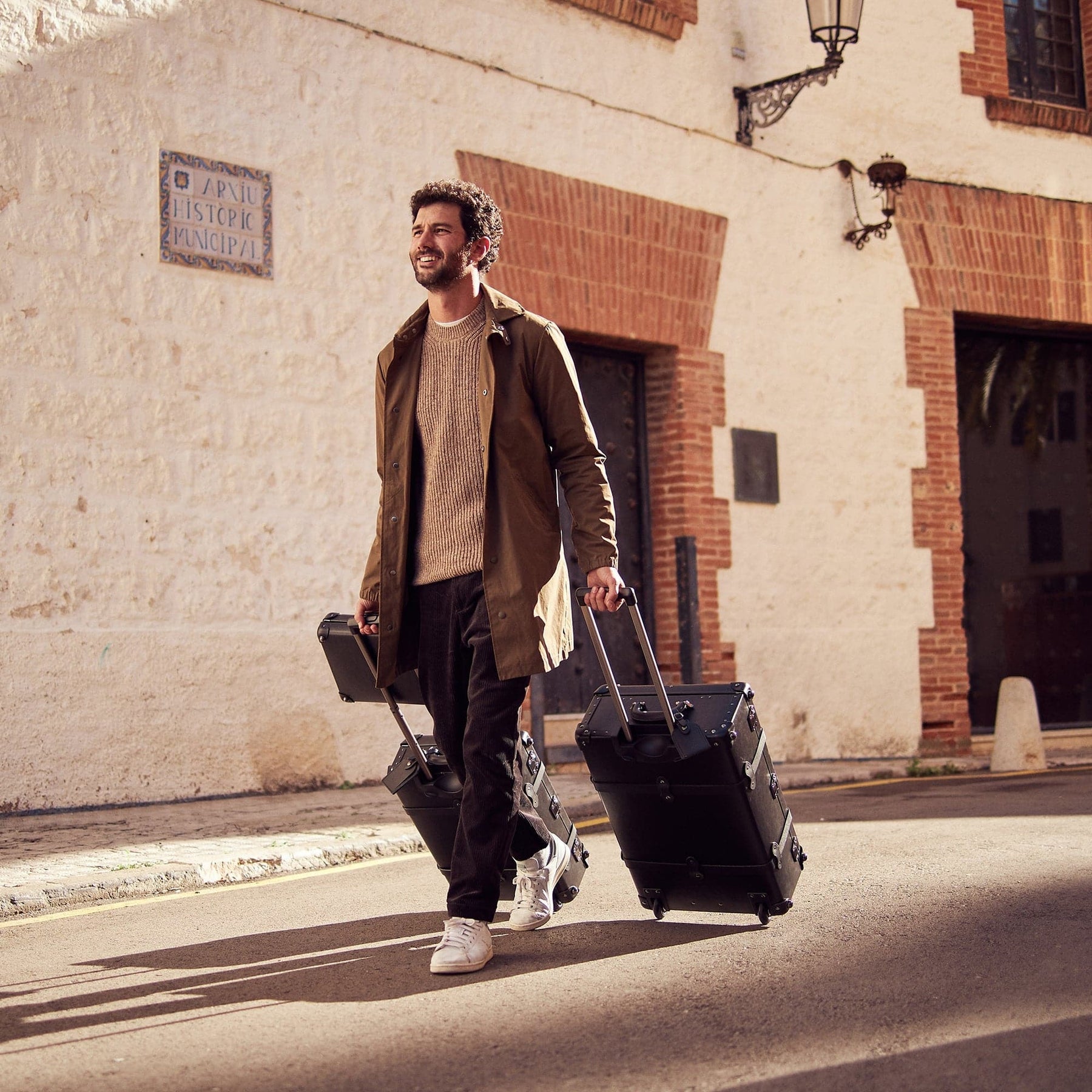 Lifestyle image of male model with the Industrialist fibreboard suitcases in black