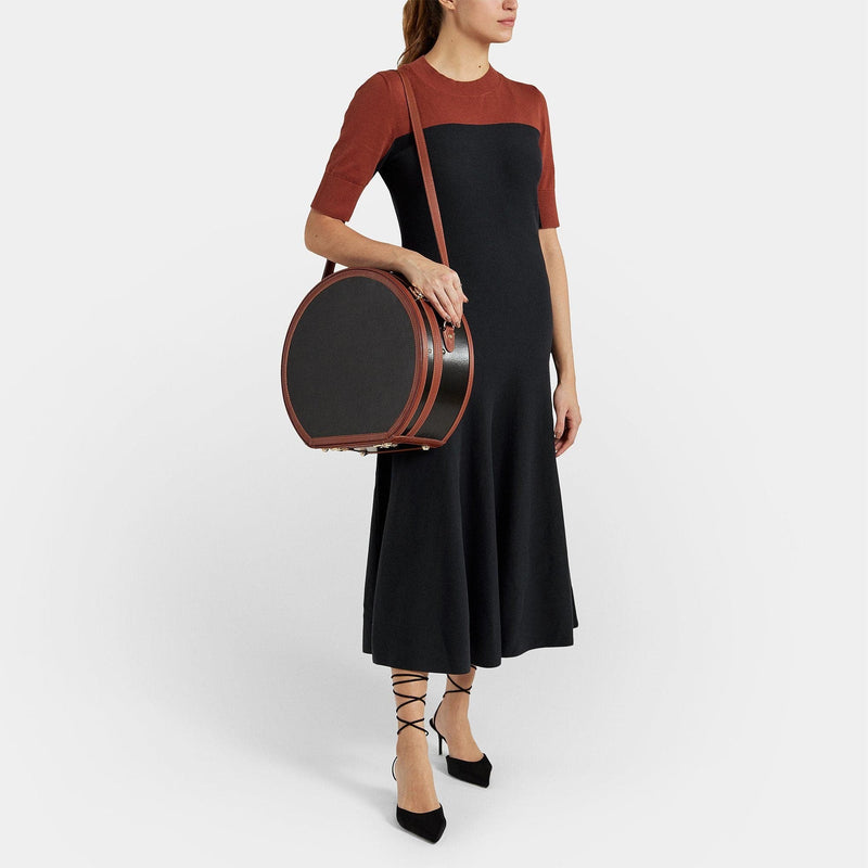 Model with the large hatbox Diplomat leather suitcase in black with shoulder attachment strap