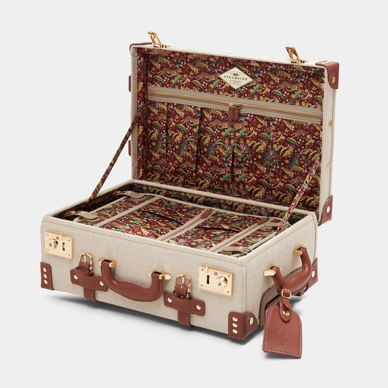 Open product view of the carry-on Editor linen suitcase with brown trims and exotic-bird print lining and brown leather luggage tag