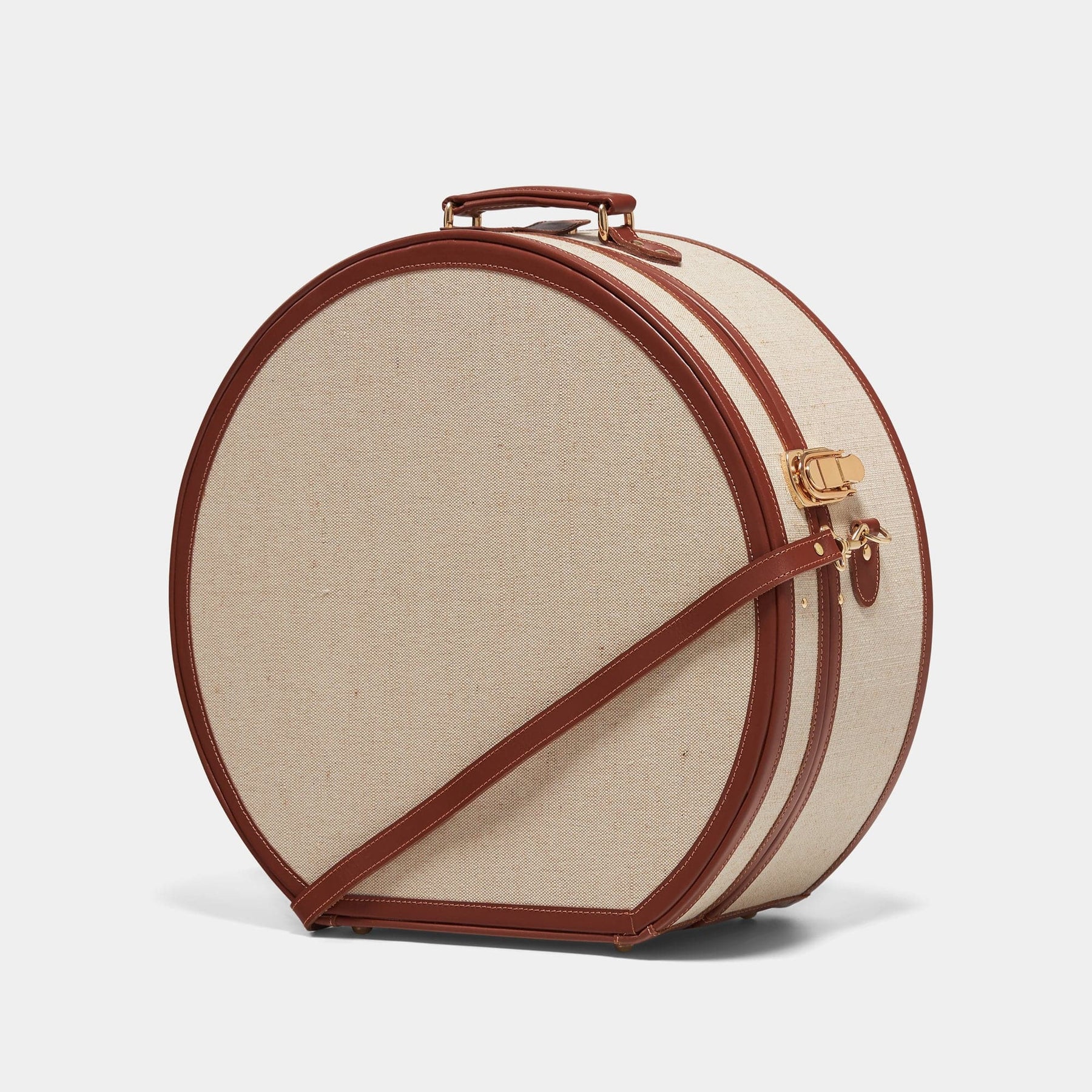 Angled product view of the deluxe hatbox Editor linen suitcase with brown trims and shoulder attachment strap