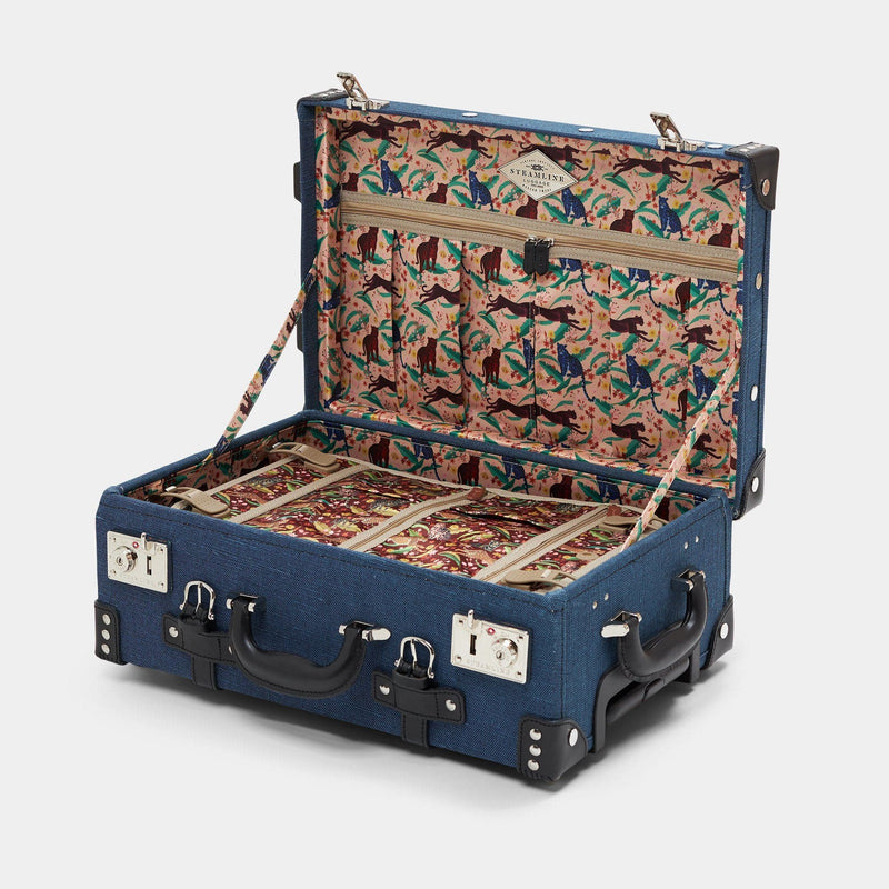 Open product view of the carry-on Editor linen suitcase with navy body and black trims and cheetah print lining and black leather luggage tag