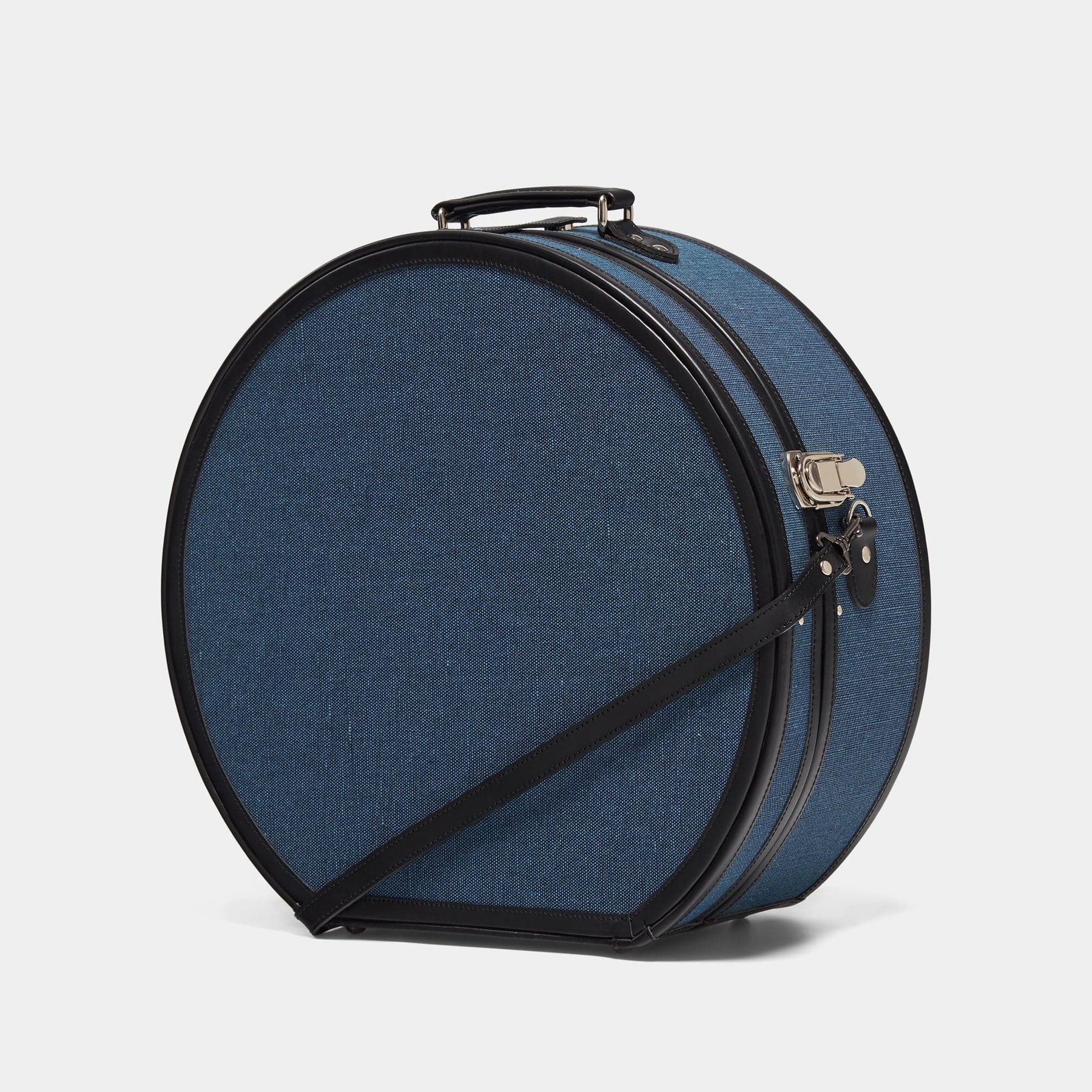 Angled product view of the deluxe hatbox Editor linen suitcase with navy body, black trims and shoulder attachment strap