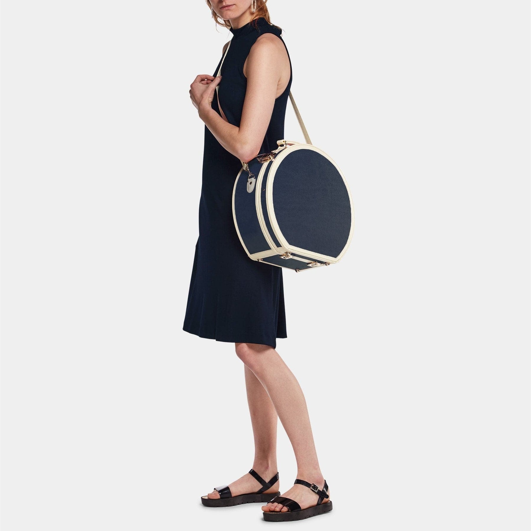 Model with the large hatbox Entrepreneur vegan leather suitcase in navy with shoulder attachment strap