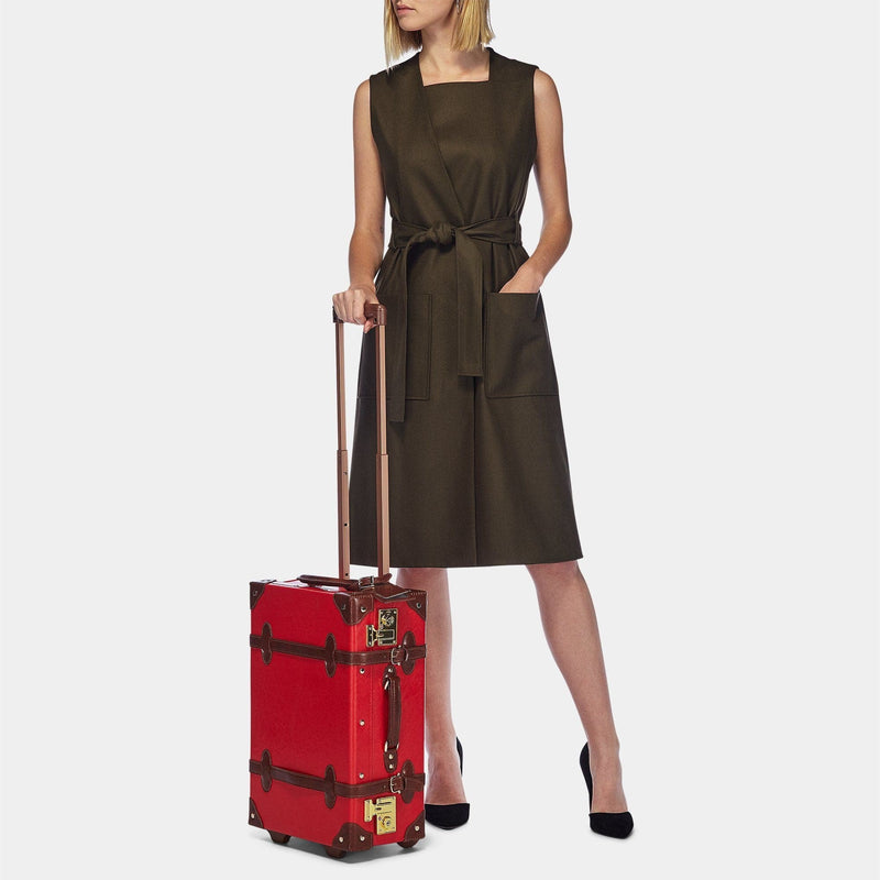 Model with the carry-on Entrepreneur vegan leather suitcase in red with raised handle