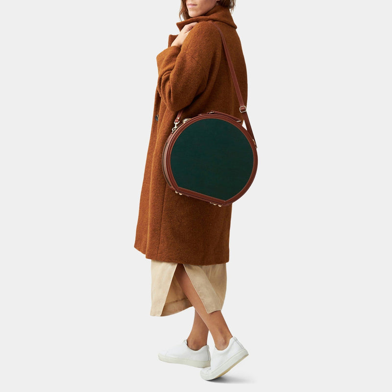 Model with the large hatbox Diplomat leather suitcase in hunter green with shoulder attachment strap