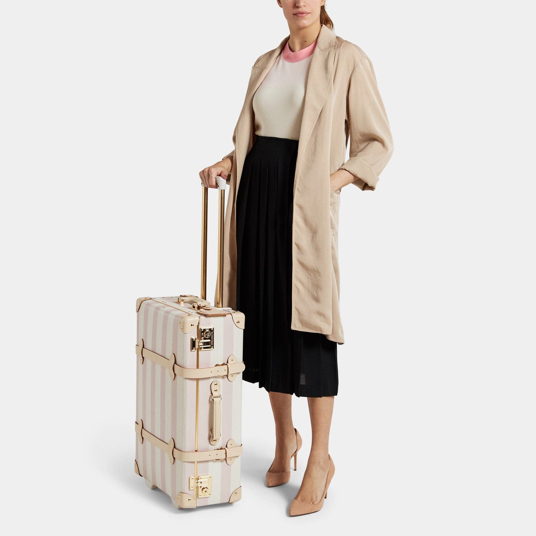 Model with the stowaway Illustrator fibreboard suitcase in pink stripe with raised handle