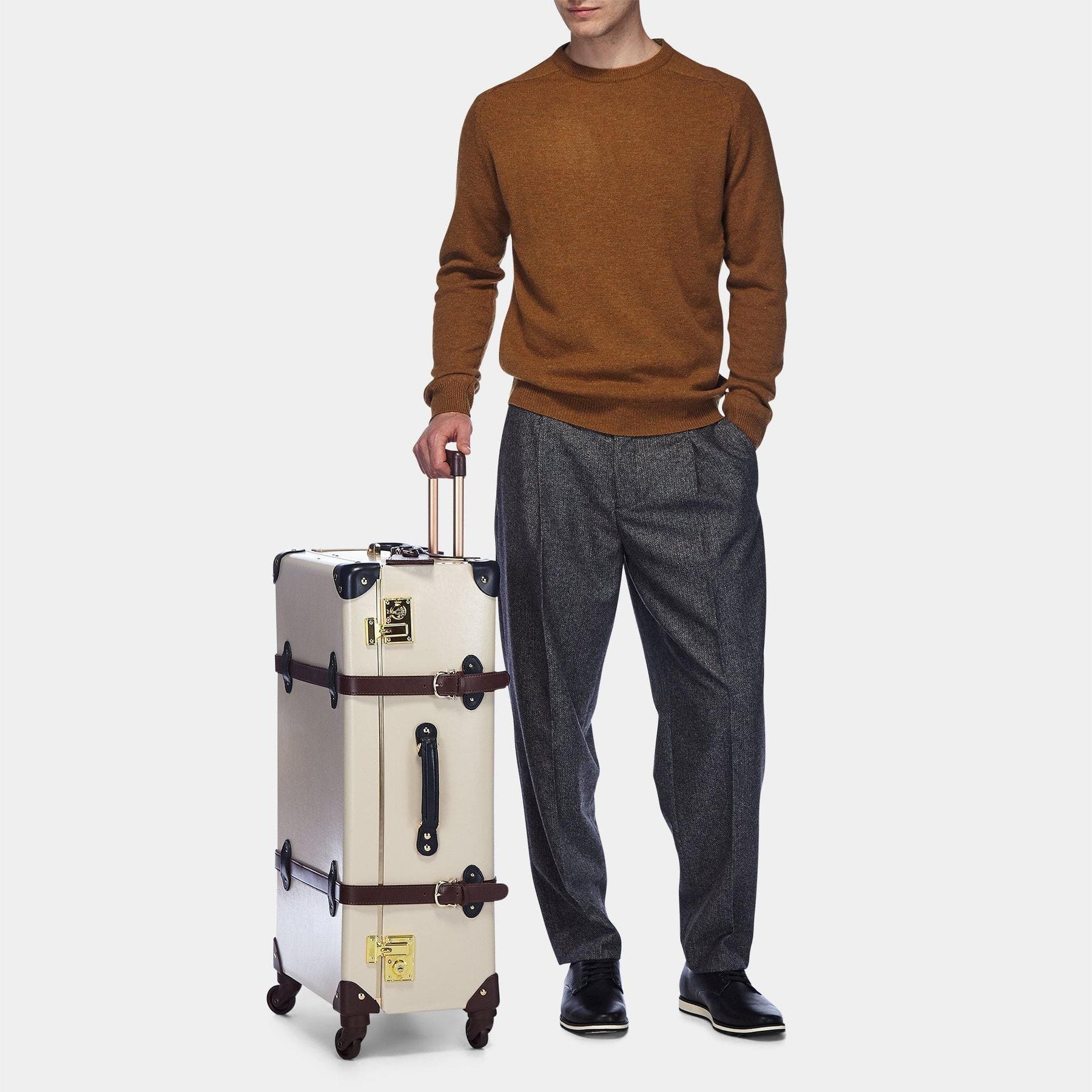 Male model with the check-in Architect leather suitcase in cream with raised handle