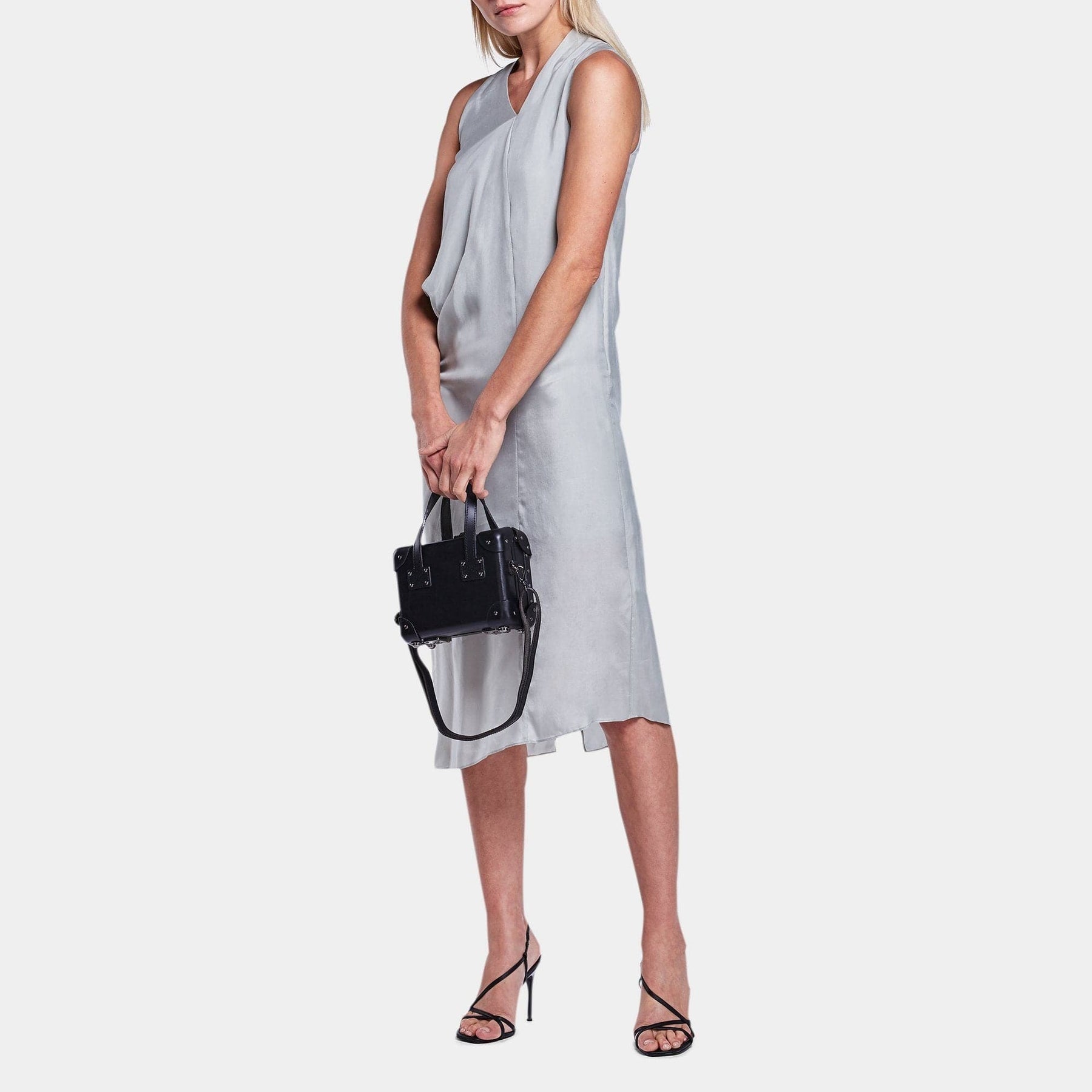 Model with the mini Industrialist fibreboard suitcase in black with shoulder attachment strap