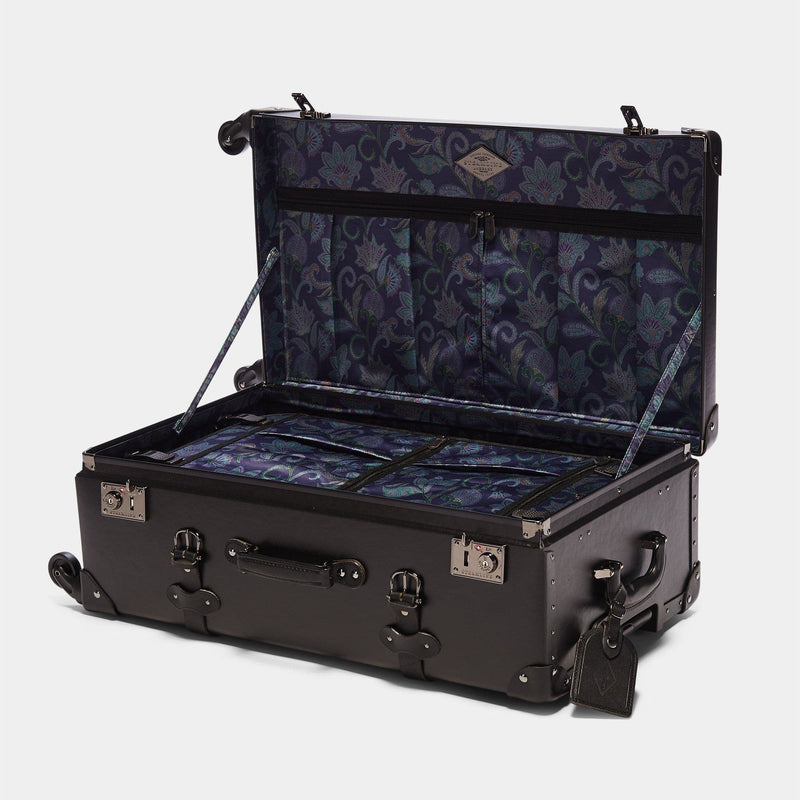 Open product view of the check-in spinner Industrialist fibreboard suitcase in navy paisley print lining and black leather luggage tag