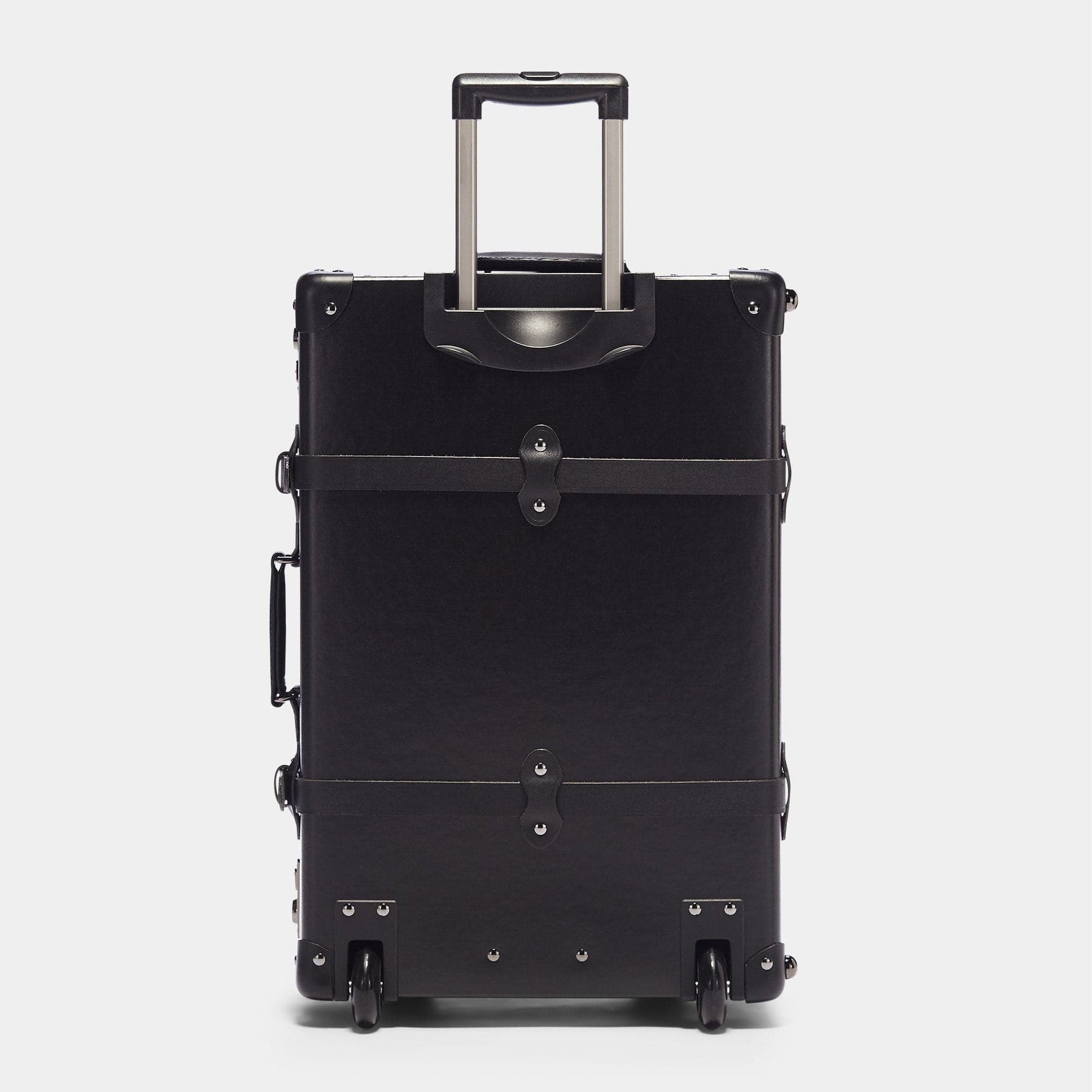 Back product view of the stowaway Industrialist fibreboard suitcase in black with raised handle