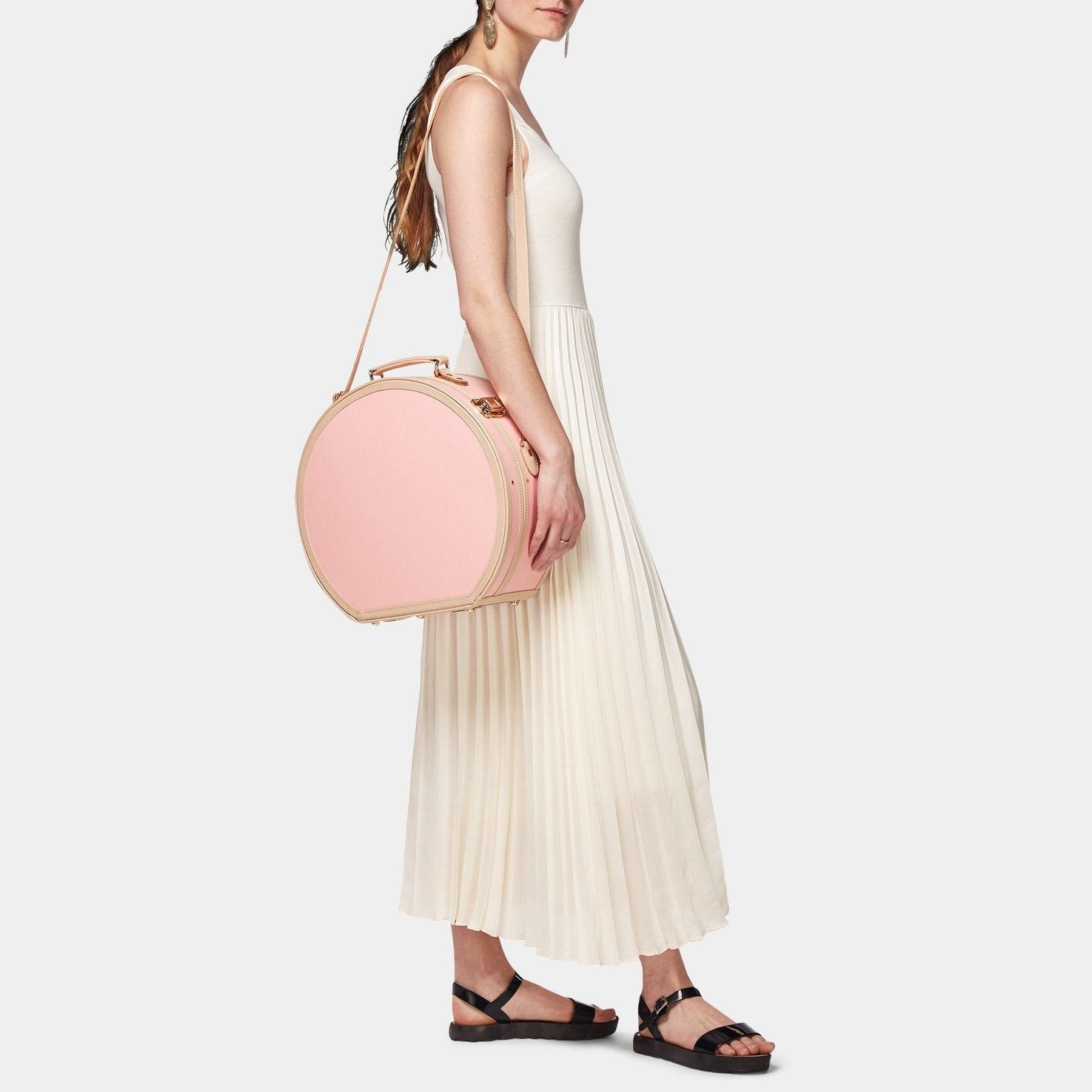 Model with the large hatbox Correspondent fibreboard suitcase in pink with shoulder attachment strap