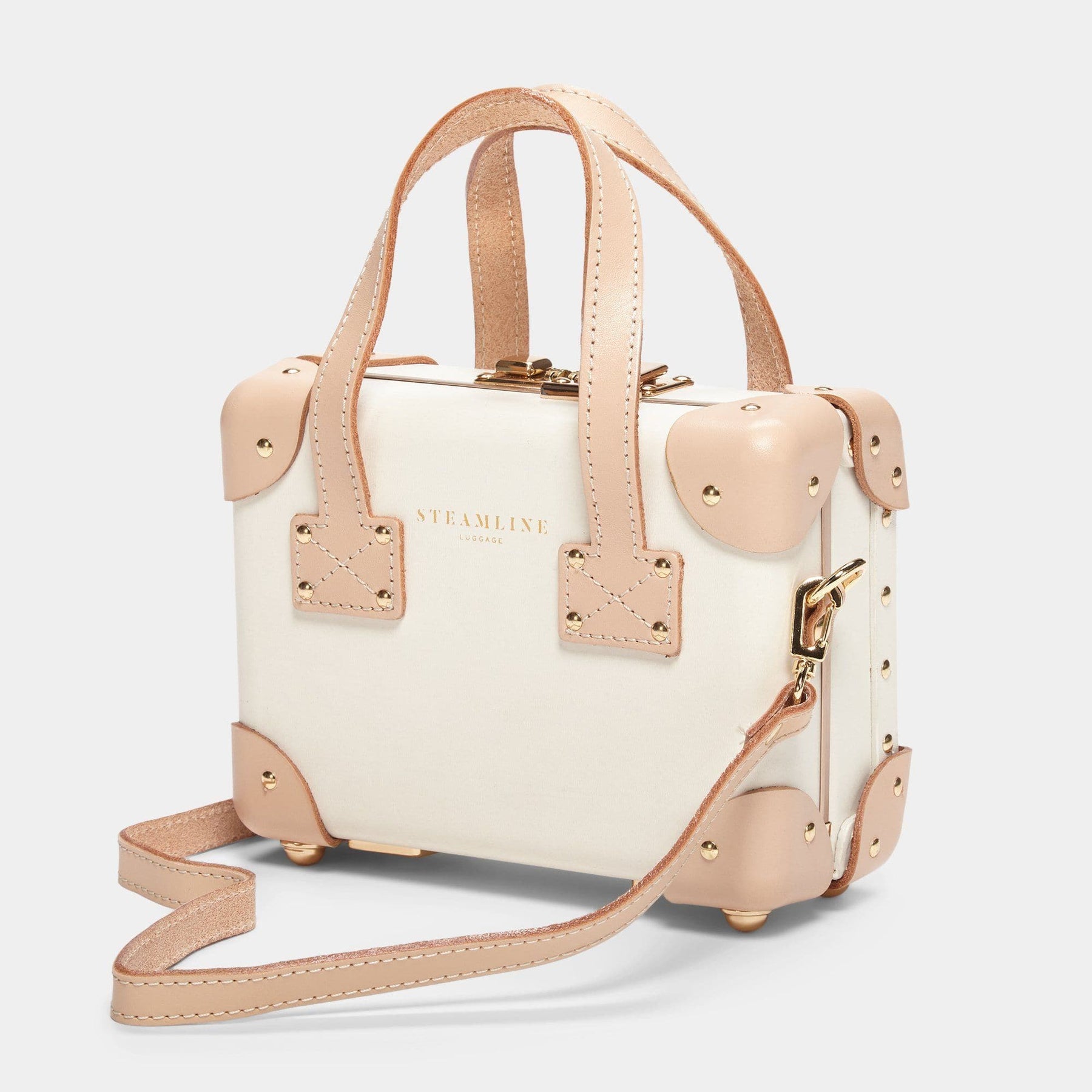 Angled product view of the mini Sweetheart fibreboard suitcase in cream with shoulder attachment strap