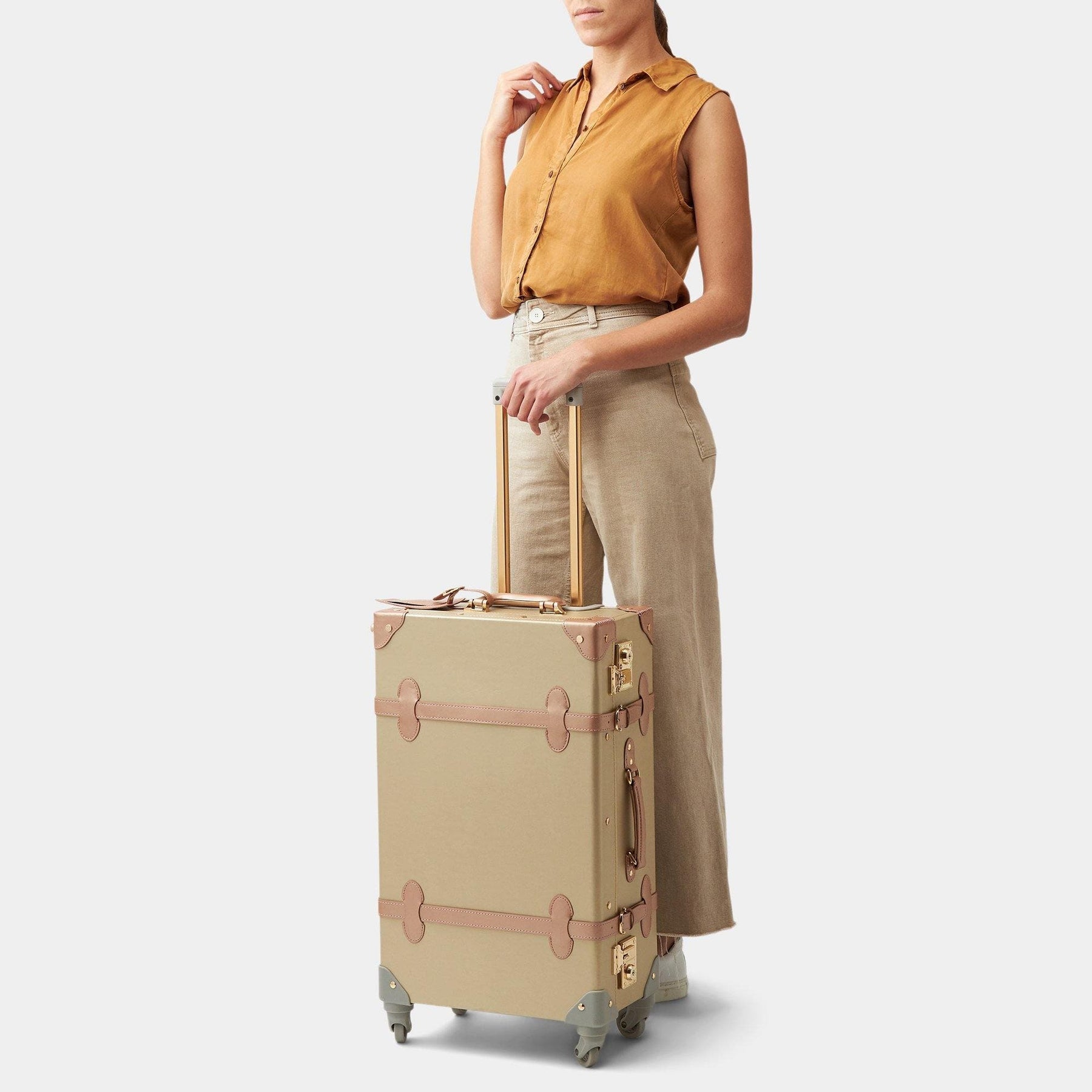 Model with the check-in spinner Alchemist vegan leather suitcase in gold