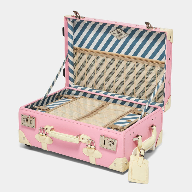 Open product view of the carry-on Entrepreneur vegan leather suitcase in pink with blue-white stripe print lining and white vegan leather luggage tag